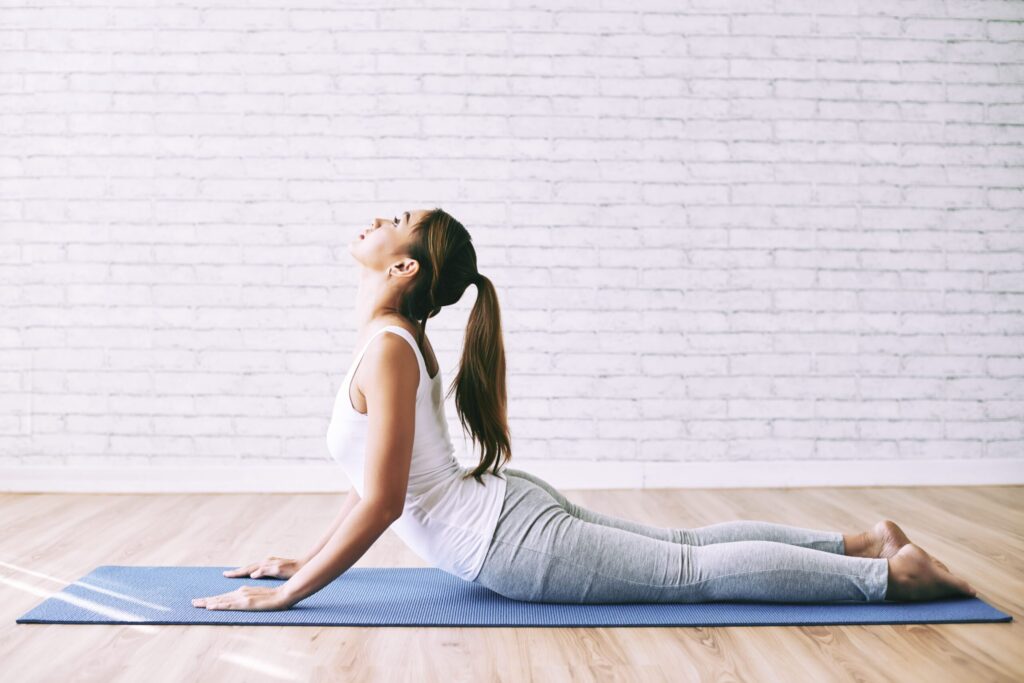 Imagem mulher alongando a coluna em postura de yoga