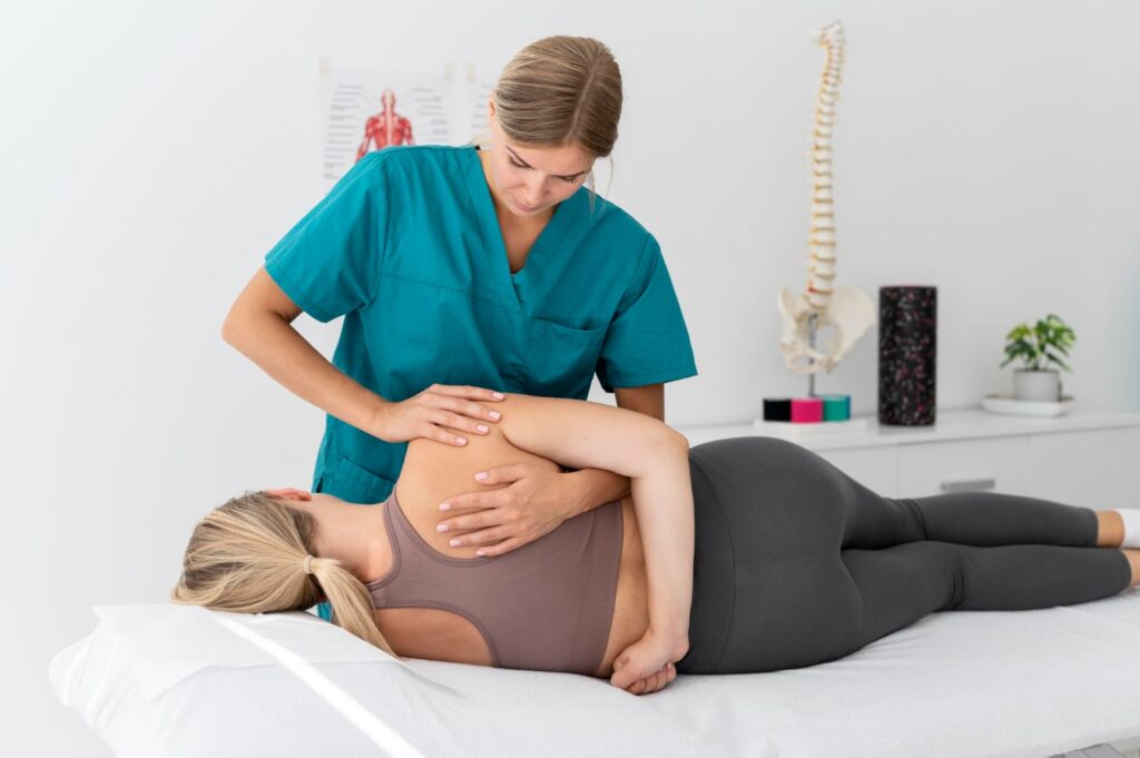 imagem de uma fisioterapeuta ajudando paciente deitada na maca com reabilitação na coluna